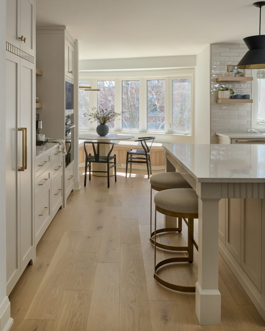 Renovated kitchen with quartz island, brass hardware and a bayed breakfast nook