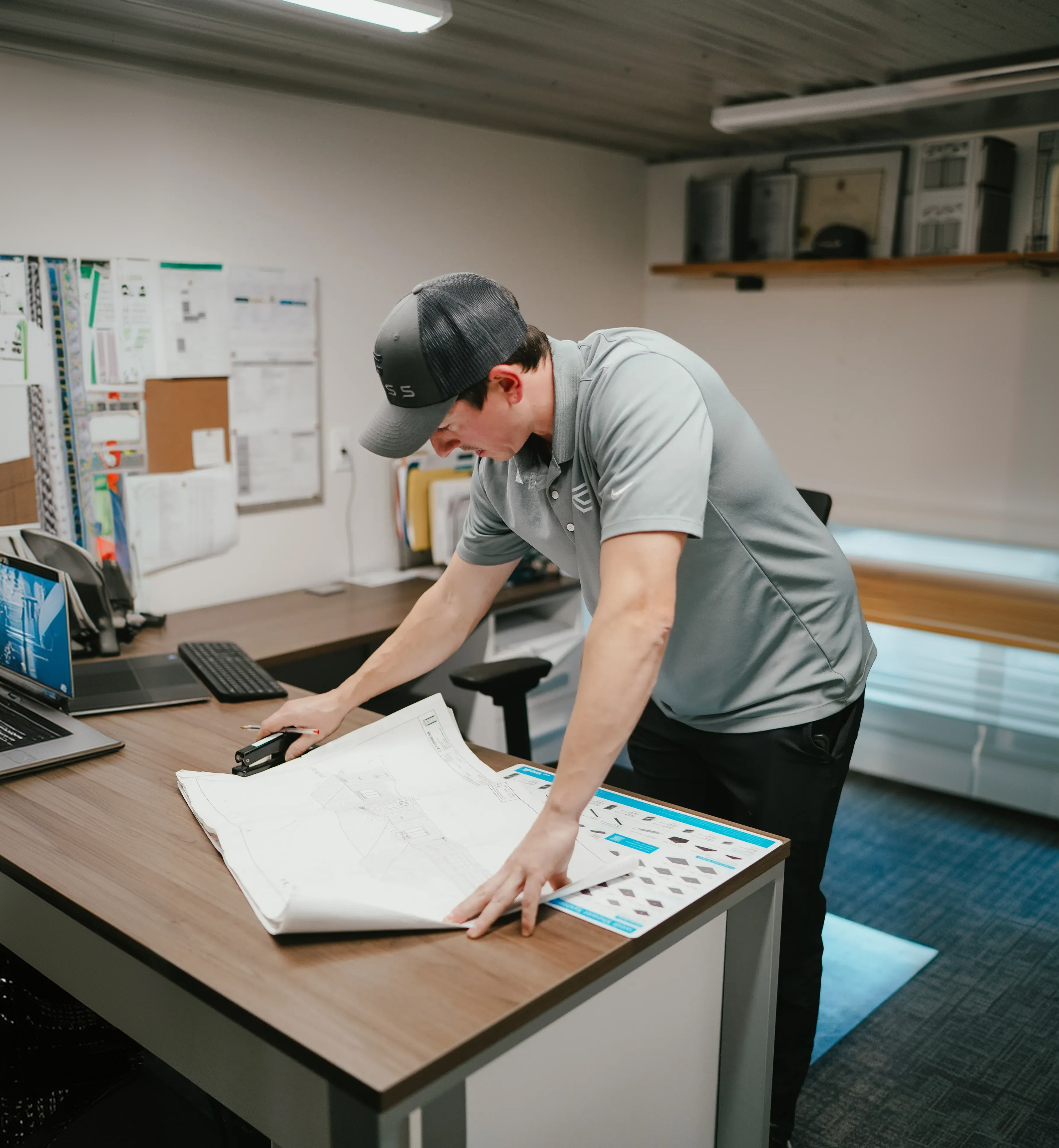 A Cass project manager laying out construction drawings on the office table
