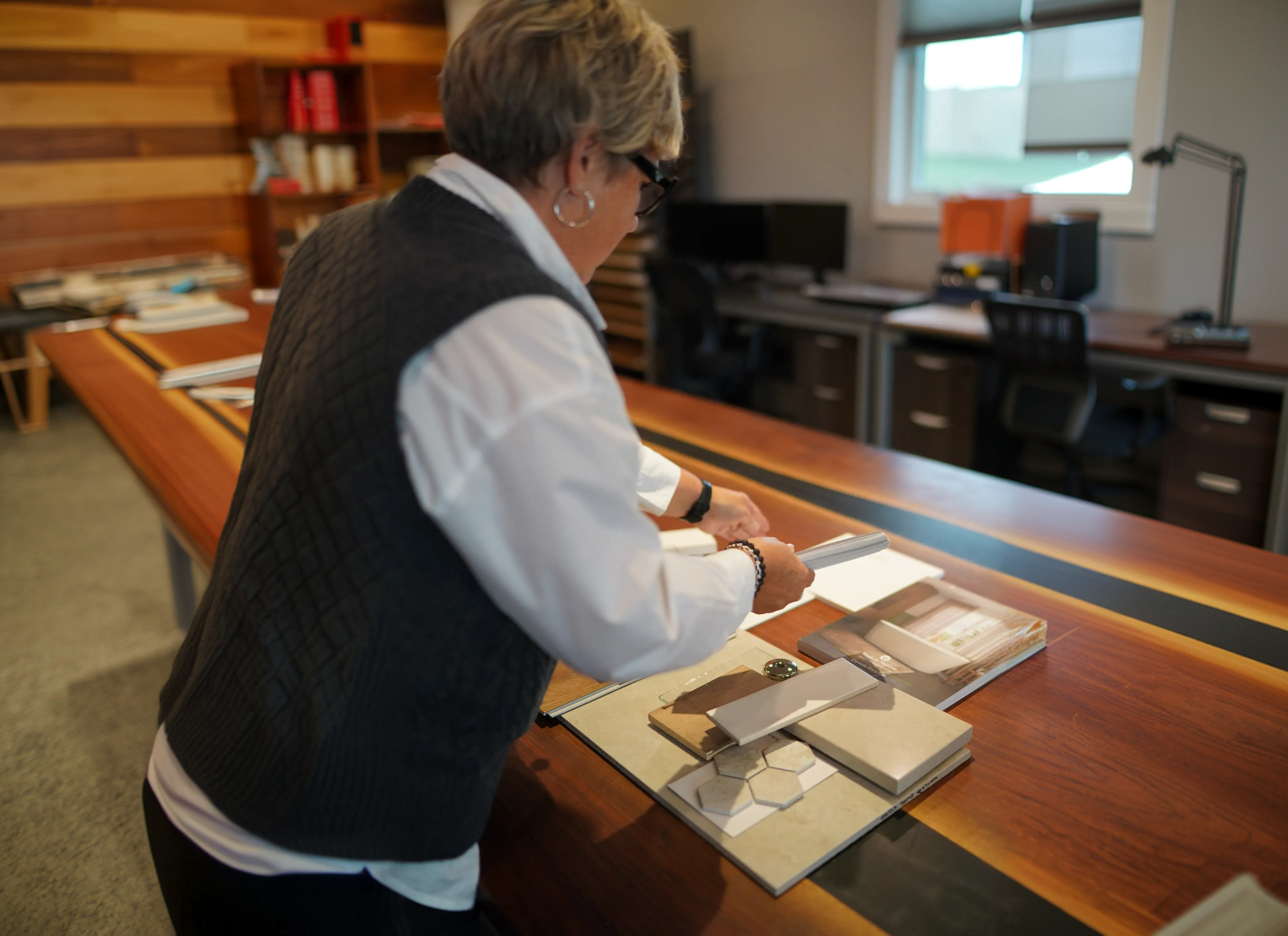 A Cass designer reviewing tile and finish samples on the studio worktable