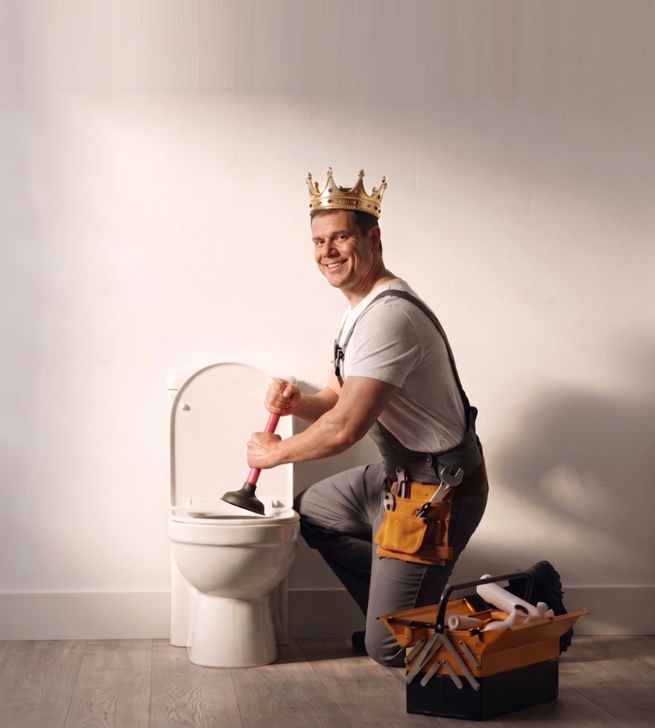 Crowned Drain King plumber clearing a toilet with a plunger