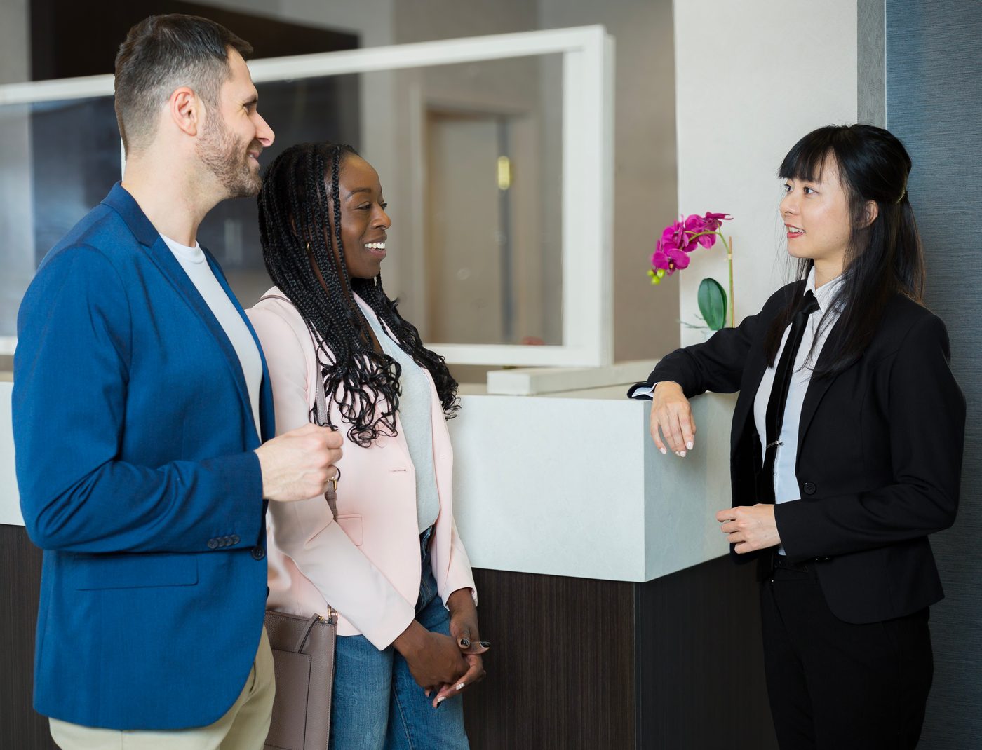 A Probe concierge warmly assisting a couple at the front desk